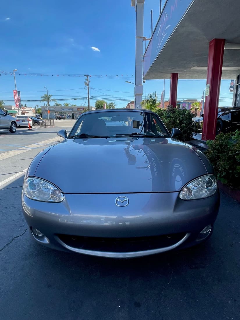 Gray Mazda MX-5 Miata convertible outside a dealership