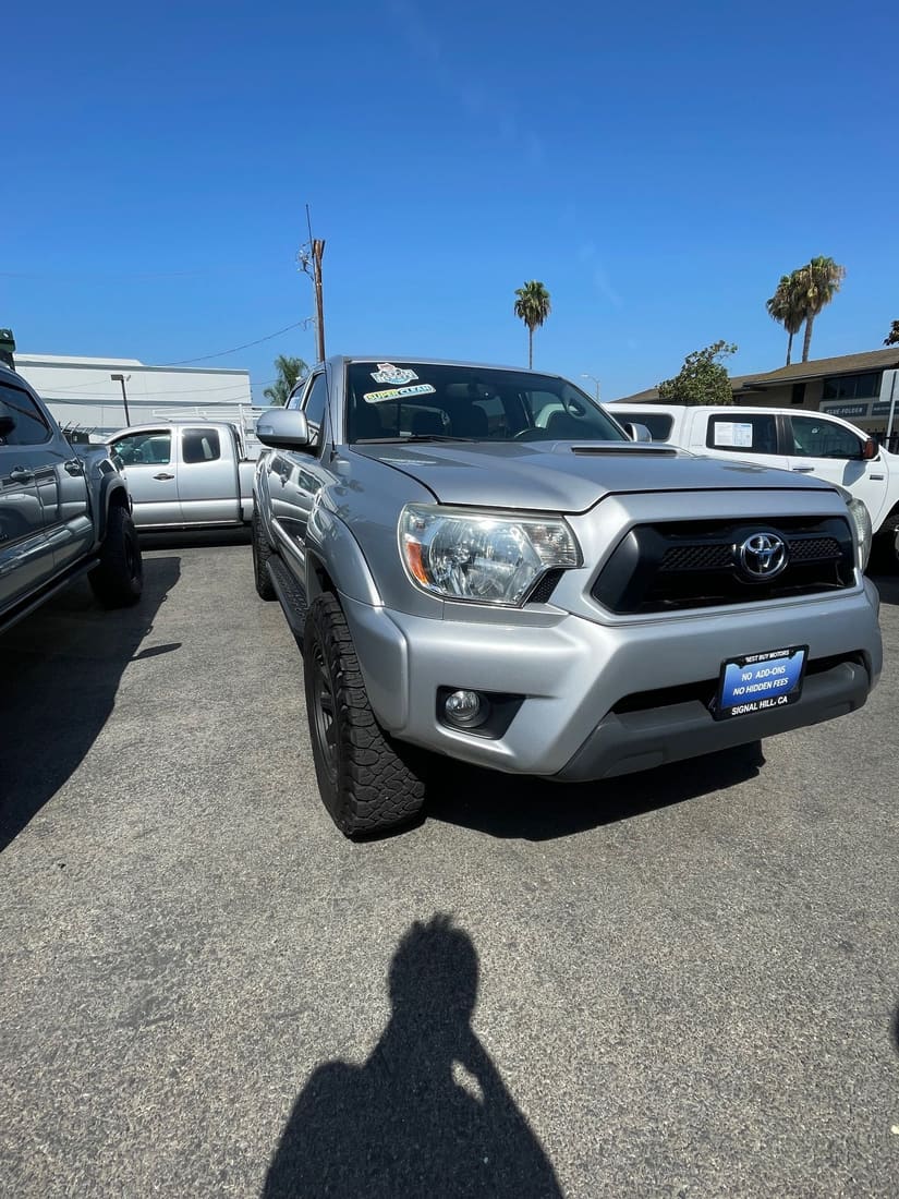 Silver Toyota Tacoma pickup on a used-car lot in Signal Hill