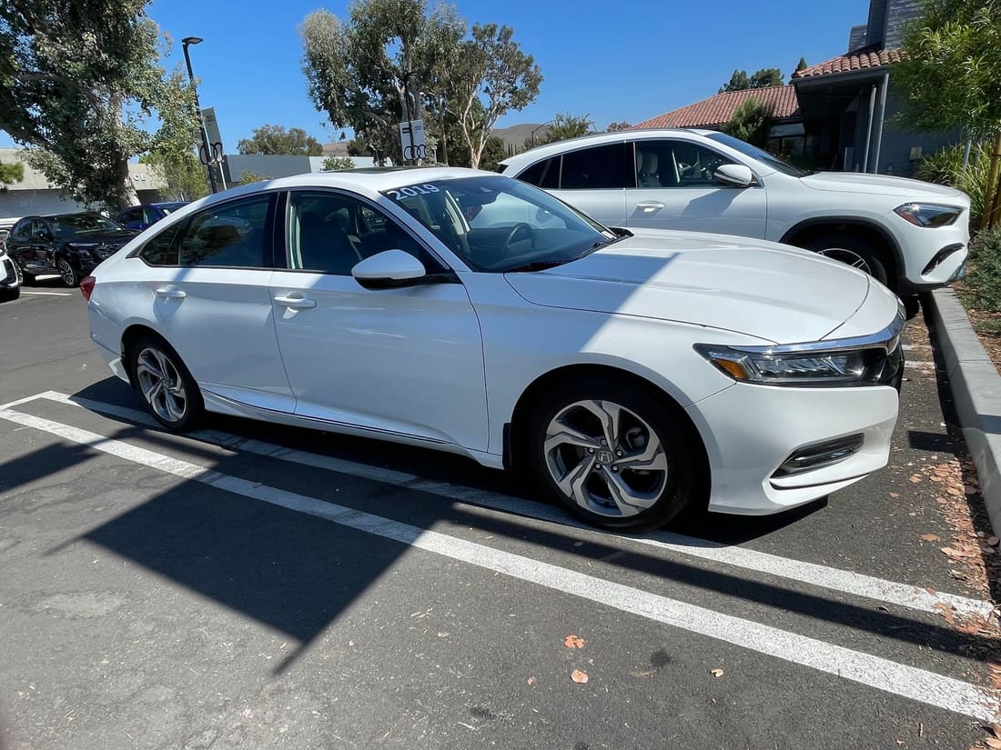 White Honda Accord sedan in a dealership parking lot
